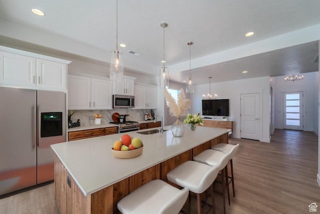 723 S 1220 W Unit 34, Hurricane, UT 84737 - kitchen featuring decorative backsplash, a spacious island, stainless steel appliances, light wood-style floors, and a sink