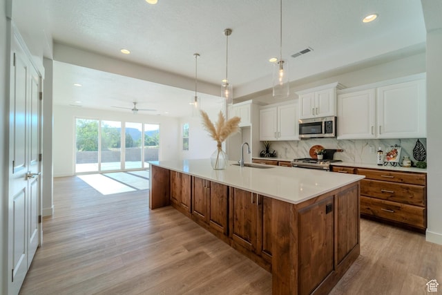723 S 1220 W Unit 34, Hurricane, UT 84737 - kitchen featuring backsplash, appliances with stainless steel finishes, light wood-style floors, white cabinetry, and a sink