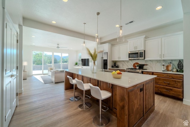 723 S 1220 W Unit 34, Hurricane, UT 84737 - kitchen with appliances with stainless steel finishes, light wood-type flooring, open floor plan, and backsplash