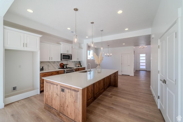 723 S 1220 W Unit 34, Hurricane, UT 84737 - kitchen with a sink, stainless steel appliances, a large island with sink, light wood-type flooring, and backsplash