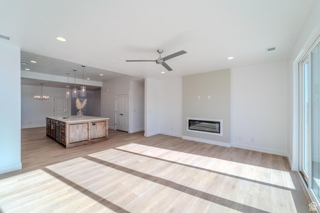 723 S 1220 W Unit 34, Hurricane, UT 84737 - unfurnished living room featuring recessed lighting, visible vents, light wood-style floors, a glass covered fireplace, and a sink