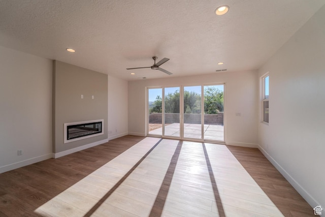 723 S 1220 W Unit 34, Hurricane, UT 84737 - unfurnished living room with recessed lighting, a textured ceiling, wood finished floors, and a glass covered fireplace