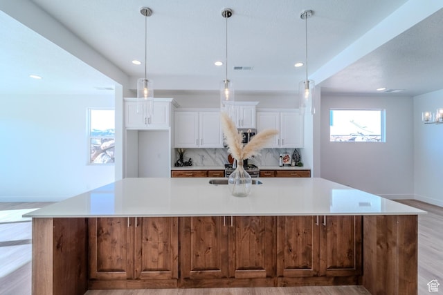 723 S 1220 W Unit 34, Hurricane, UT 84737 - kitchen featuring tasteful backsplash, a spacious island, white cabinetry, and a healthy amount of sunlight