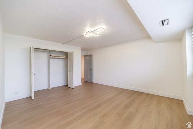 875 S Donner Way Unit 1203, Salt Lake City, UT 84108 - unfurnished bedroom featuring a closet, light wood-type flooring, and a textured ceiling