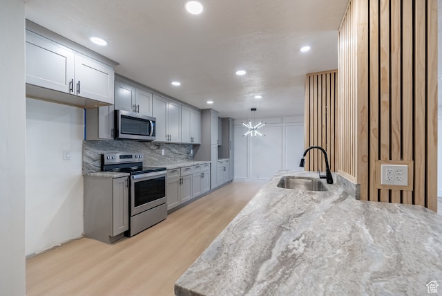 875 S Donner Way Unit 1203, Salt Lake City, UT 84108 - kitchen featuring light hardwood / wood-style flooring, stainless steel appliances, sink, light stone counters, and tasteful backsplash