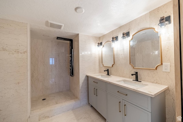 875 S Donner Way Unit 1203, Salt Lake City, UT 84108 - bathroom with a textured ceiling, vanity with extensive cabinet space, and dual sinks