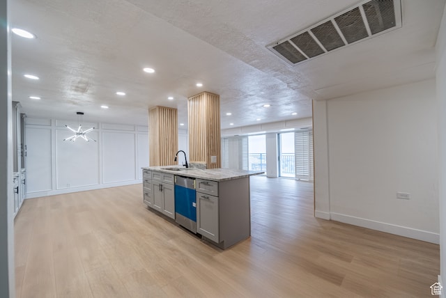 875 S Donner Way Unit 1203, Salt Lake City, UT 84108 - kitchen with light stone countertops, a center island with sink, light hardwood / wood-style floors, dishwasher, and sink