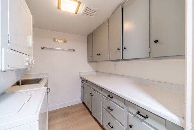 875 S Donner Way Unit 1203, Salt Lake City, UT 84108 - clothes washing area featuring light hardwood / wood-style flooring and stacked washer / drying machine