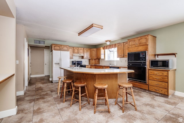 1560 E 1580 N, Logan, UT 84341 - kitchen featuring a kitchen bar, light tile floors, a kitchen island, and black appliances