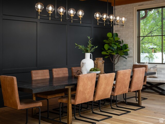 616 E Stokes Ave S, Draper, UT 84020 - dining room with brick wall, an inviting chandelier, and light hardwood / wood-style floors