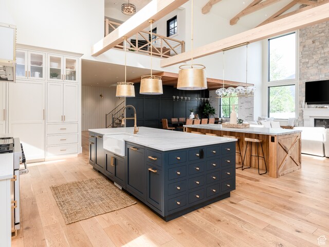 616 E Stokes Ave S, Draper, UT 84020 - kitchen featuring white cabinets, a towering ceiling, and an island with sink