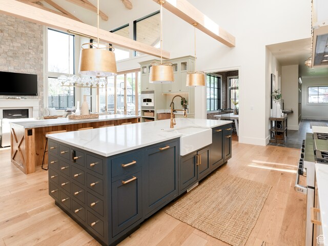 616 E Stokes Ave S, Draper, UT 84020 - kitchen featuring beamed ceiling, light hardwood / wood-style flooring, sink, a center island with sink, and pendant lighting