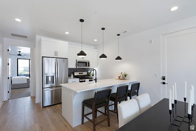 400 S Moki Dr Unit I-1, Kanab, UT 84741 - kitchen featuring stainless steel appliances, a kitchen breakfast bar, white cabinetry, backsplash, and light countertops