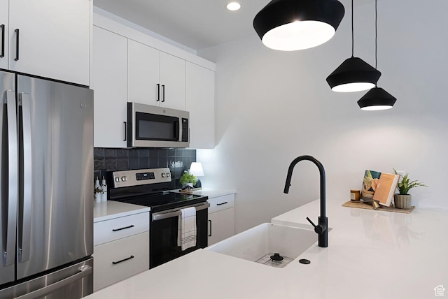 400 S Moki Dr Unit I-1, Kanab, UT 84741 - kitchen with appliances with stainless steel finishes, light countertops, decorative backsplash, white cabinetry, and decorative light fixtures
