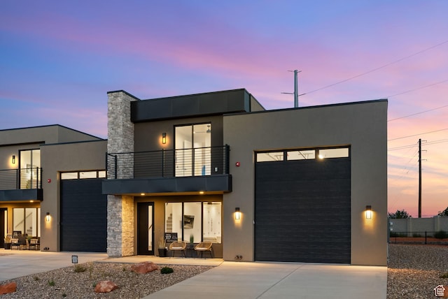 400 S Moki Dr Unit I-1, Kanab, UT 84741 - modern home featuring a balcony, concrete driveway, a garage, stone siding, and stucco siding