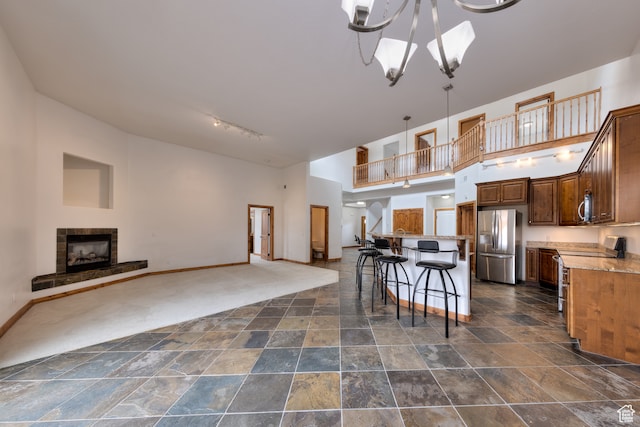 1145 E Bonita St, Moab, UT 84532 - kitchen with appliances with stainless steel finishes, dark tile floors, a notable chandelier, a tiled fireplace, and decorative light fixtures