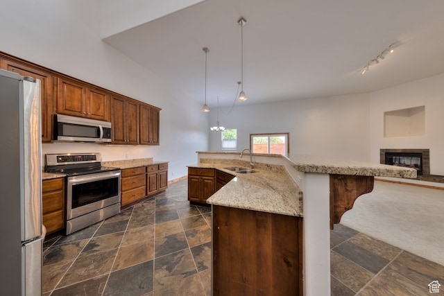 1145 E Bonita St, Moab, UT 84532 - kitchen featuring pendant lighting, a kitchen island with sink, a fireplace, appliances with stainless steel finishes, and sink