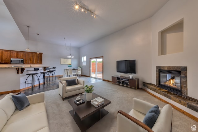 1145 E Bonita St, Moab, UT 84532 - living room featuring high vaulted ceiling, track lighting, a fireplace, and an inviting chandelier