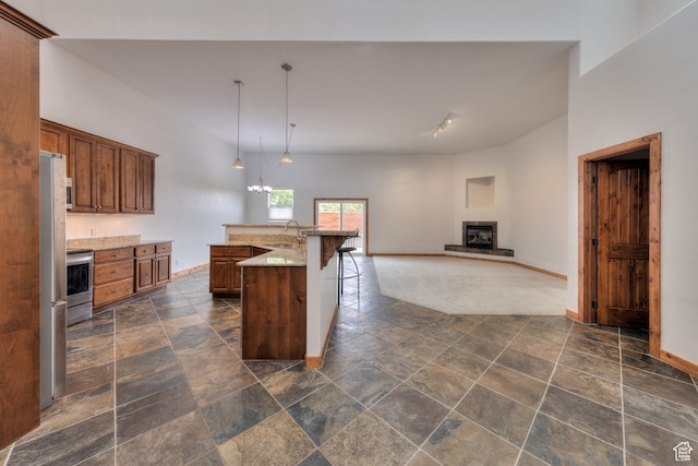 1145 E Bonita St, Moab, UT 84532 - kitchen featuring pendant lighting, a breakfast bar, range, a center island with sink, and dark tile flooring