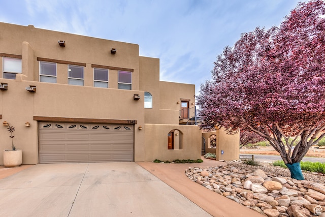 pueblo revival-style home with a garage