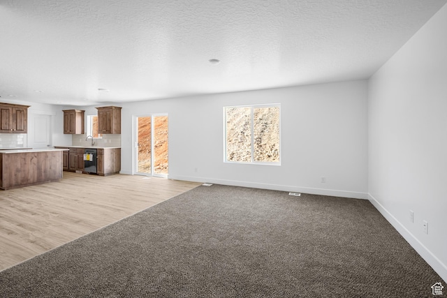 1698 S Marigold Unit 242, Santaquin, UT 84655 - unfurnished living room featuring baseboards, light carpet, a sink, and light wood-style floors