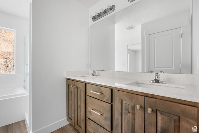 1698 S Marigold Unit 242, Santaquin, UT 84655 - full bathroom featuring wood finished floors, double vanity, a tub, and baseboards