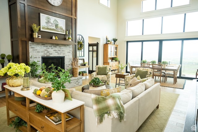 living room with a fireplace, wood finished floors, and a towering ceiling
