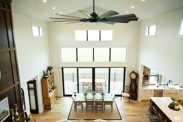 interior space with light wood-style floors, ceiling fan, recessed lighting, and a high ceiling