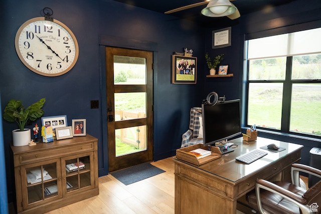 home office with a ceiling fan, a healthy amount of sunlight, and light wood-style flooring