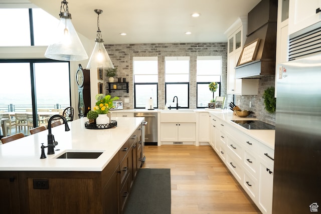 kitchen featuring stainless steel appliances, white cabinetry, a sink, and dark brown cabinets