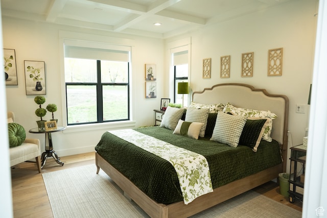 bedroom featuring baseboards, beamed ceiling, coffered ceiling, and wood finished floors
