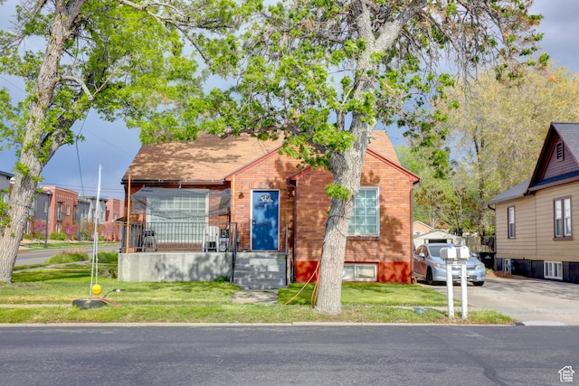 bungalow-style home with a front yard