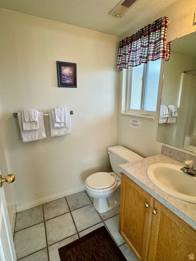 888 N Newburg Dr Unit 1, Garden City, UT 84028 - bathroom featuring toilet, vanity, tile patterned flooring, a textured ceiling, and baseboards