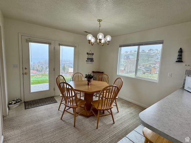888 N Newburg Dr Unit 1, Garden City, UT 84028 - carpeted dining space featuring healthy amount of natural light, a chandelier, a textured ceiling, and baseboards