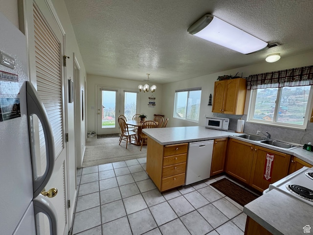 888 N Newburg Dr Unit 1, Garden City, UT 84028 - kitchen with dishwashing machine, a sink, freestanding refrigerator, white microwave, and a peninsula