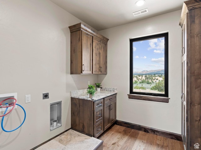 laundry room featuring hookup for an electric dryer, light wood-style flooring, visible vents, cabinet space, and hookup for a washing machine