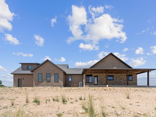 rear view of house with stucco siding and central AC