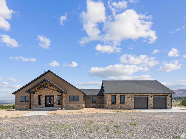 view of front of house featuring driveway, a shingled roof, a garage, and french doors