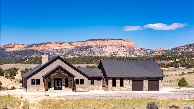 modern farmhouse style home with a mountain view, a chimney, a garage, and french doors