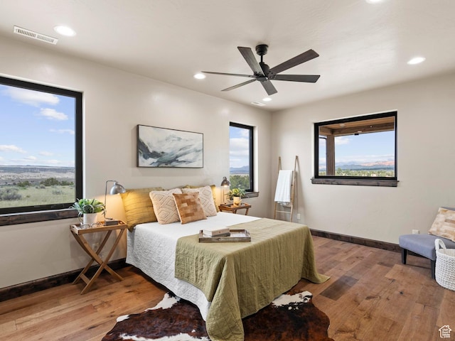 bedroom featuring visible vents, baseboards, recessed lighting, a ceiling fan, and wood-type flooring