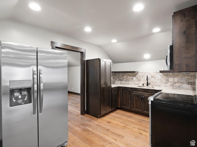 kitchen with lofted ceiling, a sink, dark brown cabinets, and appliances with stainless steel finishes