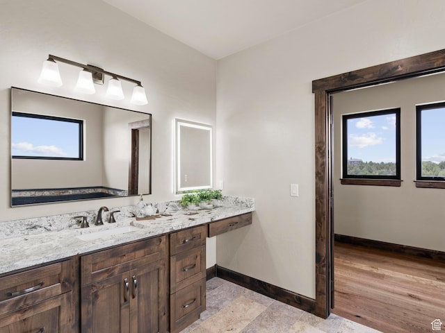 bathroom with baseboards, wood finished floors, and vanity