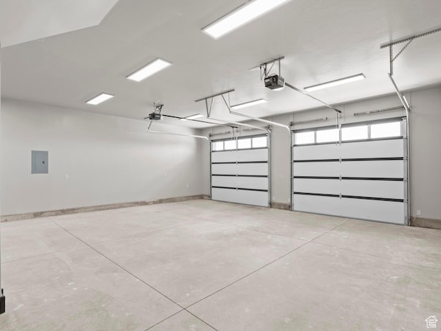 garage featuring electric panel, a garage door opener, and baseboards