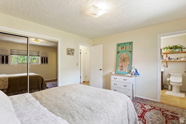 142 S Eccles Ave, Ogden, UT 84404 - tiled bedroom featuring connected bathroom, a closet, and a textured ceiling