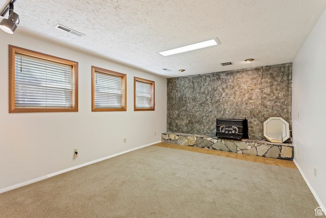 142 S Eccles Ave, Ogden, UT 84404 - interior space with a textured ceiling, a wood stove, a fireplace, and carpet
