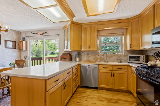 142 S Eccles Ave, Ogden, UT 84404 - kitchen with appliances with stainless steel finishes, a healthy amount of sunlight, light hardwood / wood-style flooring, and kitchen peninsula