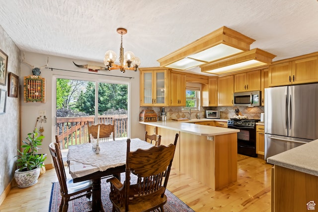 142 S Eccles Ave, Ogden, UT 84404 - kitchen featuring plenty of natural light, light hardwood / wood-style flooring, stainless steel appliances, and an inviting chandelier