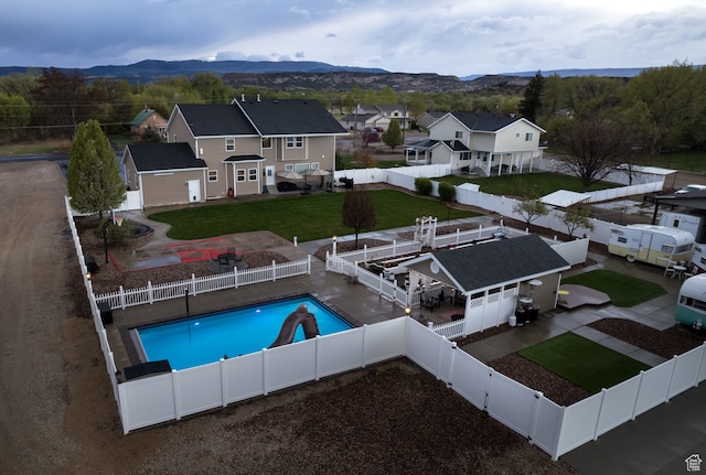 2120 N 2500 W, Vernal, UT 84078 - view of swimming pool featuring a patio area, a lawn, a mountain view, an outdoor structure, and a water slide
