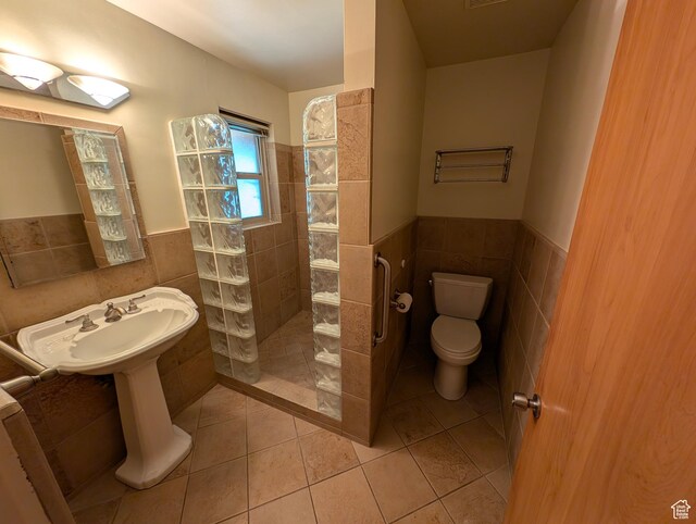 1235 E 820 N, Provo, UT 84606 - full bathroom with tile walls, a walk in shower, tile patterned floors, toilet, and a wainscoted wall