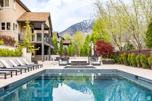 view of swimming pool featuring an outdoor living space, a patio area, and a mountain view
